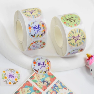 Macro shot of colorful floral Thank You stickers on a roll for gift packaging