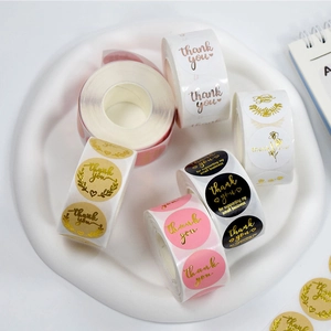 Assorted gold foil thank you stickers in pink, black and white for business packaging