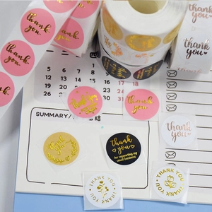 Pink and black gold-stamped Thank You stickers in a roll for wedding gift packaging