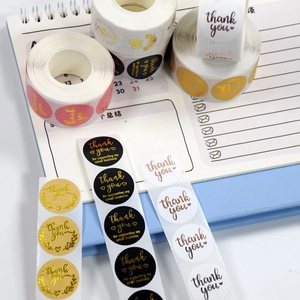 Close-up of assorted round pink and black gold foil thank you sealing stickers for gifts