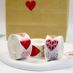 Detailed view of red heart-shaped sticker rolls on a decorative tray for gift wrapping