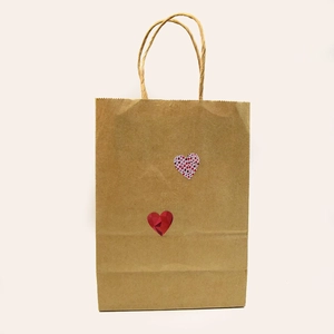 Brown kraft paper gift bag featuring red heart patterns and matching twisted rope handles