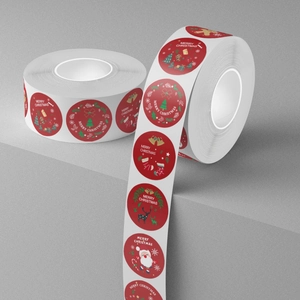 Two rolls of red Merry Christmas stickers with Santa and reindeer on grey pedestal