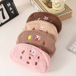 Detail of four fluffy cookie pencil cases with cute facial embroidery and zipper