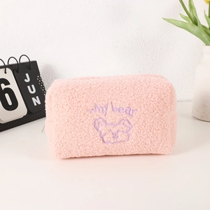 Detail of soft pink sherpa pencil case with cute purple bear embroidery and texture