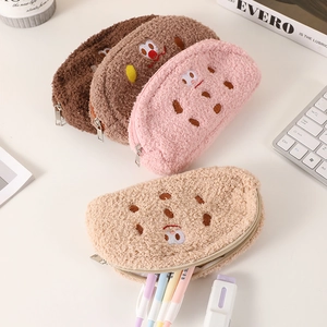 Cute cookie plush pencil cases in four colors on a desk with stationery and accessories