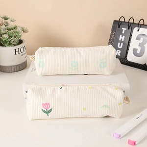 Detail view of cream corduroy pencil bags featuring floral tulip and daisy patterns