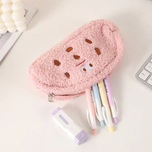 Pink plush pencil case with cute embroidery holding pens on a clean white desk