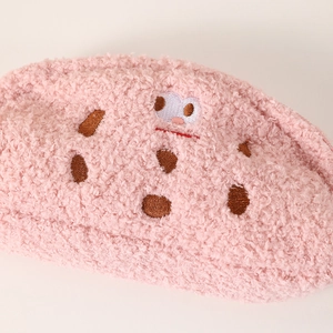 Close-up of pink plush pencil case featuring soft fleece texture and cute cartoon embroidery