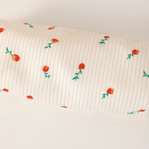Close-up of floral pencil case fabric with red flowers and vertical striped texture