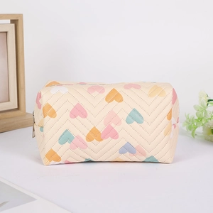 Detail of cream pencil case with colorful heart prints and 3D chevron quilted texture