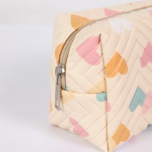 Close-up of quilted heart pattern pencil case with metallic zipper and premium PU texture