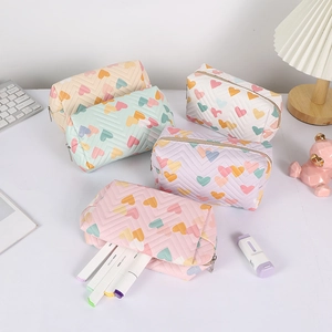 Pastel ruffled pencil cases with heart patterns and gold zippers in five soft colors
