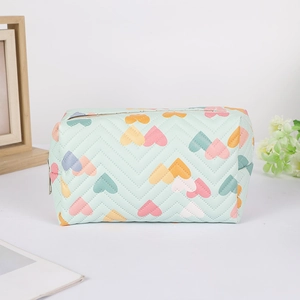 Detail of mint green quilted pencil case with colorful heart patterns and V-stitch texture