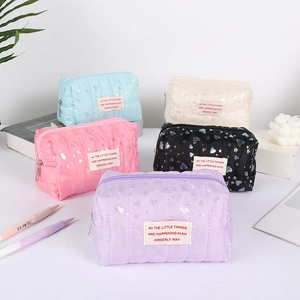 Detailed view of quilted heart pattern pencil cases in five pastel colors with zip closure