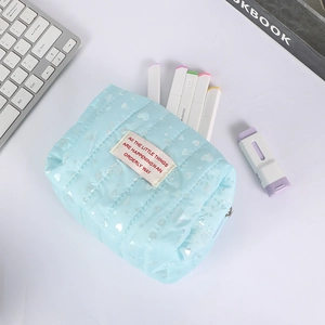 Detailed view of light blue quilted pencil case featuring holographic heart prints
