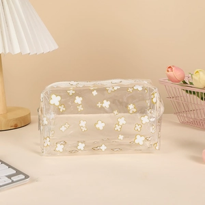 Macro detail of transparent pencil case with clover patterns and top zipper closure