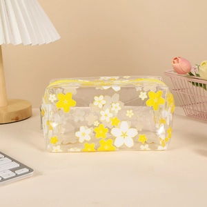 Detailed view of a clear PVC pencil case with yellow cherry blossom print and sturdy zipper