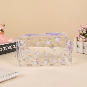 Macro view of clear PVC pouch with purple zipper and gold-edged clover prints