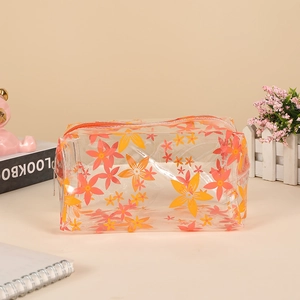 Transparent PVC makeup bag with bright orange flower prints and metal zipper detail