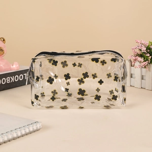 Detail view of transparent PVC storage bag featuring black and gold clover patterns
