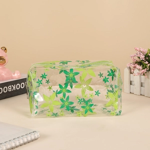 Detail of transparent PVC pencil case featuring green floral patterns and zipper closure