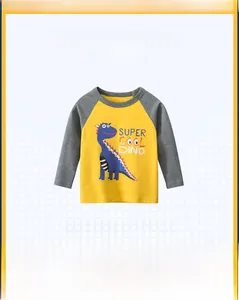 Detail of kids yellow raglan tee with grey sleeves and blue dinosaur cartoon graphic