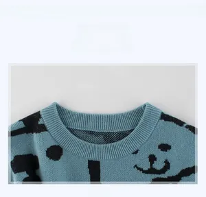 Detail view of the ribbed crew neck and black bear print on a light blue knit sweater