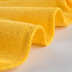 Detalle de tela de sudadera de algodón amarillo brillante con costuras y textura suave