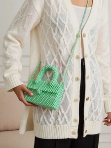 Detail of mint green beaded handbag with woven texture and matching shoulder strap