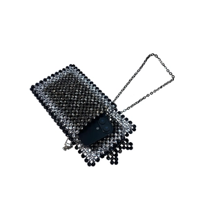 Detail of beaded mobile phone bag with black tassels and silver chain strap