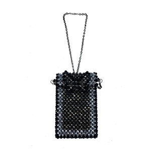 Detail of hand-woven black beaded phone bag with metallic chain and checkered texture