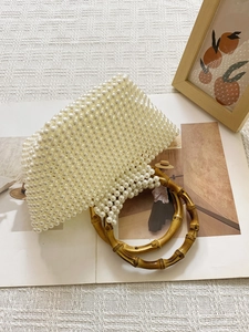 Detail of handmade pearl beaded handbag featuring vintage bamboo round dual handles