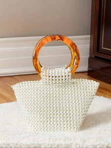 White faux pearl woven handbag with elegant amber resin ring handles for evening parties