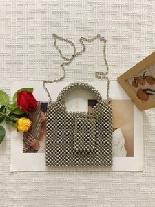 Silver beaded acrylic handbag with top handle and metal chain strap on white background