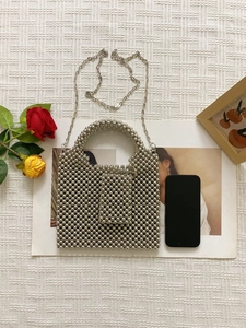Silver beaded tote bag with chain strap and mini purse on elegant floral background