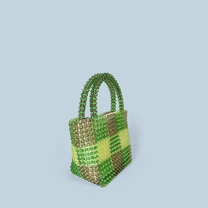 Macro view of handmade green checkered beaded handbag with sturdy curved top handles