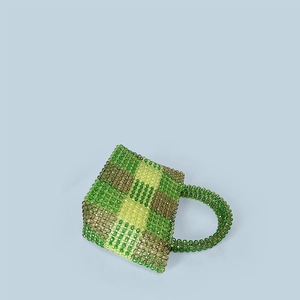 Detail of handmade woven beaded handbag with green and yellow checkered pattern beads