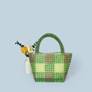 Close-up of handmade beaded tote bag with green and yellow checkered pattern and acrylic handles