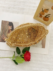 Detailed shot of golden beaded woven tote bag with metallic shine for luxury evening look