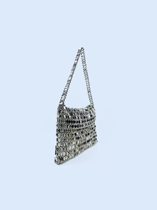 Modern metallic silver sequin chainmail tote bag with shoulder strap on blue background
