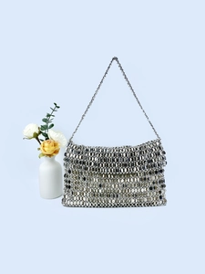 Vintage silver sequin handbag with metal chain strap shown against a light blue backdrop