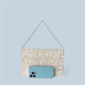 Detail of white beaded tote with sequins and phone for scale on blue backdrop