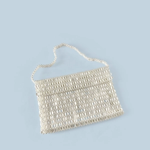 Macro shot of silver sequin woven texture and metallic beaded handle on this evening tote bag