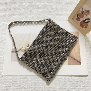Detail of hand-woven gunmetal metallic sequins showing scale-like texture on tote bag