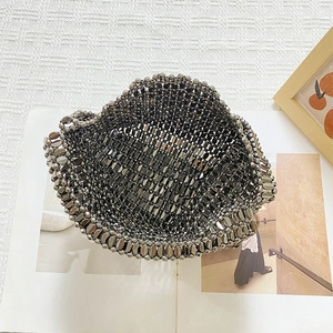 Detail shot of a handmade metallic beaded tote bag with a woven hollow structure on a magazine