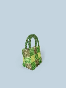 Green and yellow checkered beaded handbag with round handles on a light blue background