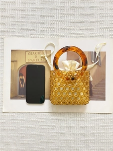Amber acrylic beaded bucket bag with tortoiseshell handles and satin drawstring pouch