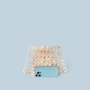 Detail of handmade beaded pearl crossbody bag with pink satin drawstring liner