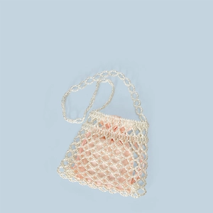 Detail of hand-woven pearl mesh bag featuring pink satin drawstring inner pouch